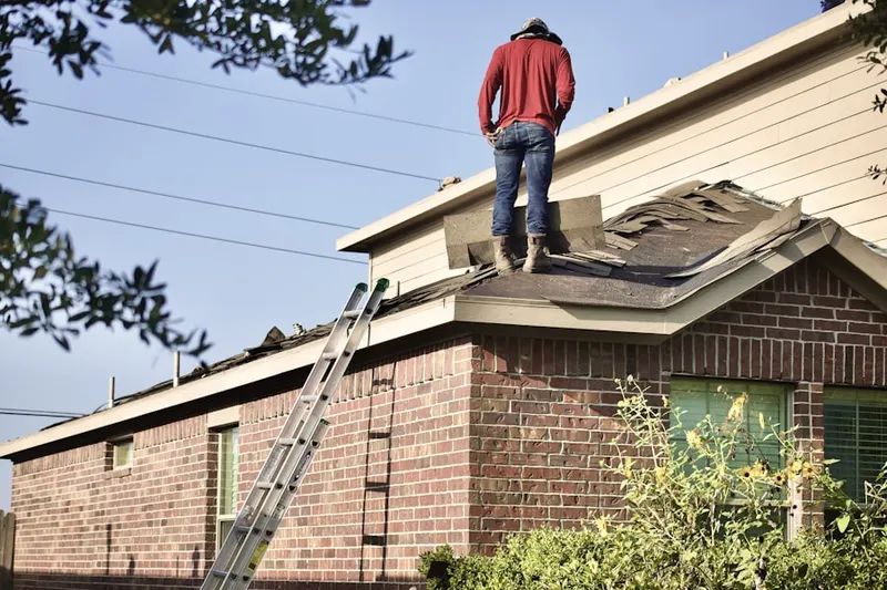 Professional roofer working on a residential roof in Plowed Neck